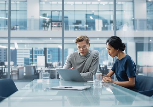 Multiethnic Diverse Office Conference Room Meeting: Team of Two Creative Entrepreneurs Talk, Discuss Growth Strategy. Stylish Young Businesspeople work on Investment and Marketing Projects.