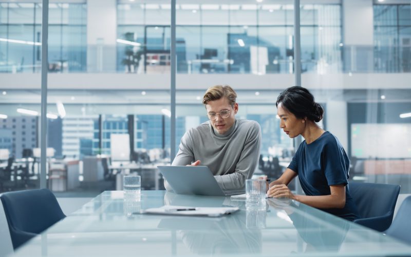 Multiethnic Diverse Office Conference Room Meeting: Team of Two Creative Entrepreneurs Talk, Discuss Growth Strategy. Stylish Young Businesspeople work on Investment and Marketing Projects.